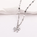 Gros plan du collier avec pendentif nœud argenté et zircons sur socle en pierre blanche - Style 6-Noeud Papillon Minimaliste Or Blanc