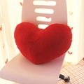 Red heart-shaped plush throw pillow placed on a white chair for modern home decor - Red Heart