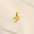 Detail eines goldenen Buchstaben-F-Anhängers mit Verschluss auf beigem Seidenstoff - Buchstabe-F / Gold