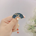 Detailed view of vintage enamel fan brooch with magpie patterns and pearl pendants - Blue Fan