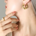 U-shaped gold-plated twisted hoop earrings with green zircon stones on female model - Large / Gold with Green Zircon