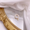Close-up of a freshwater pearl ring with a golden letter N charm on a mirror surface - Letter N