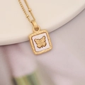 Close-up of golden butterfly pendant necklace with textured shell inlay on white tray - Gold Square Butterfly Style (5#)