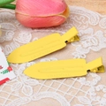 Macro detail of yellow matte finish metal duckbill clips on a delicate lace background - Yellow