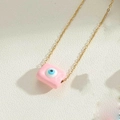 Dettaglio del ciondolo rettangolare rosa con occhio di Allah su catena dorata elegante - Rosa