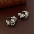Détail des boucles d'oreilles argentées en forme de C multicouches sur fond de cuir - Style de Gamme Torsadée Argentée (HE10656)
