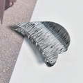 Close-up of a silver medium metal hair claw with brushed texture on a minimalist surface - White K Alloy Brushed Heart Hair Claw