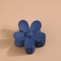 Détail macro d'une pince à cheveux fleur bleu foncé avec une texture mate givrée - Bleu marine
