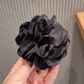Elegant black satin camellia flower hair tie featuring a multilayered folded petal design - Black