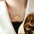 Golden square pendant necklace with woven edge and engraved text on elegant woman - 39+5cm / Gold