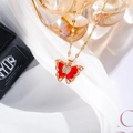 Detail of red butterfly pendant necklace with micro-pave crystals on silk background - Red