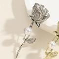 Detailansicht einer silbernen Rosenbrosche mit glitzernden Strasssteinen und Perle - Stahlsilber Rose Blume