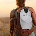 Close-up of black leaf-shaped PU leather magnetic hat clip attached to a travel backpack - Black