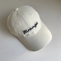Gros plan de la broderie « Hiranga » sur une casquette de baseball en coton beige - Blanc Cassé