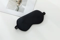 Black 22 momme mulberry silk sleep mask with elastic strap on a minimalist background - Black