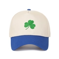Detail of green shamrock embroidery on a five-panel cream and blue trucker hat - Beige Crown + Royal Blue Brim