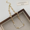 Detailed close-up of Baroque pearl necklace with gold threaded chain and lobster clasp - Multi-pearl Necklace