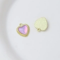 Macro detail of heart charm with pink stone, beaded gold edge and textured back - Style 15