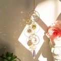 Detail of crystal suncatcher with sun face pendant casting rainbow reflections on wall - QHM3181 Triple Circle Crystal Ornament