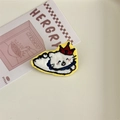 Detailed embroidery of a white cartoon cat patch with a red crown and blue scarf - Crown Cat