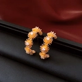 Makroaufnahme von 18k vergoldeten Blumen-Ohrsteckern mit funkelnden Zirkonia-Steinen - Gold