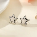 Macro detail of silver pentagram stud earrings with a high-polished metallic finish - Silver