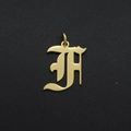 Macro shot of gold stainless steel letter H pendant with ring for DIY jewelry making - Letter F