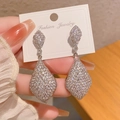 Silver teardrop earrings encrusted with white cubic zirconia on a jewelry card - Silver
