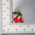 Macro view showing dimensions of a red cherry pendant with green leaves for jewelry making - Style 9