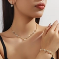 Dettaglio di elegante set dorato con collana, orecchini e bracciale con inserti in cristallo - Collana Orecchini Bracciale (80808602) / Oro