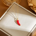 Close-up of a delicate red chili pendant necklace with a polished gold chain detail - Gold Chili