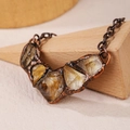 Detailed macro shot of vintage raw citrine stones set in antique copper casing on wood - Citrine Smile Chain / Yellow Citrine