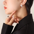 Silver drop earrings with white marble stone and matching dark gem ring on model - Steel Color White Turquoise Earrings