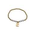 Detail of gold beaded and white pearl bracelet with engraved letter F square pendant - Letter F