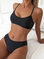 Detail view of a black two-piece bikini set with thin straps and elastic fabric on model - S / Black