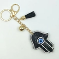 Hamsa-Hand Schlüsselanhänger in Schwarz und Gold mit blauem Auge und Quaste - Schwarz