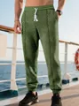 Detalle del pantalón jogger verde oliva para hombre con textura jacquard y cordón blanco - S / Verde