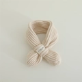 Detailansicht eines cremefarbenen Rippstrickschals mit Webetikett für Babys und Kinder - Kleines Etikett Stil / Beige