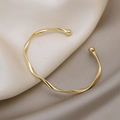 Minimalist golden twisted open bangle with round spherical ends and high-polish finish - Gold Twisted Bangle