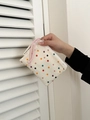 Close-up of beige canvas makeup bag with colorful polka dots and pink braided rope - Small White Polka Dot