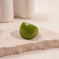 Macro view of olive green resin square ring on natural stone with artistic background - Green