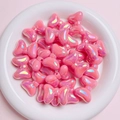 Close-up of pink iridescent bow-shaped beads with a central hole for DIY jewelry making - Rose Red