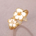 Elegant gold ring featuring two white enamel camellia flowers with sparkling zircon details - US 10 / Gold