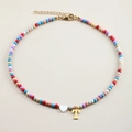 Detail of colorful beaded necklace with white heart and gold letter T pendant charms - Letter T