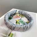 Close-up of a grey pleated satin headband with a French retro twisted design on a book - Smoke