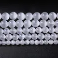 Makroaufnahme weißer Selenit-Rundperlen in fünf Größen auf schwarzem Hintergrund - 6mm/Ca. 60 Perlen pro Strang / Natürlicher weißer Katzenaugenstein