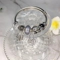 Silver dreamcatcher charm bracelet with heart lock and star pendants on marble - Black