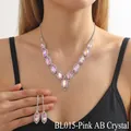 Macro shot of V-shaped pink AB crystal necklace and drop earrings with white stones - Iridescent Pink