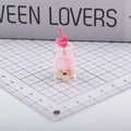 Miniature pink heart-topped glowing bottle keychain with cute crying face expression - Hot Pink