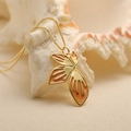 Minimalist gold chain necklace featuring an orange enamel flower petal pendant - Light Orange